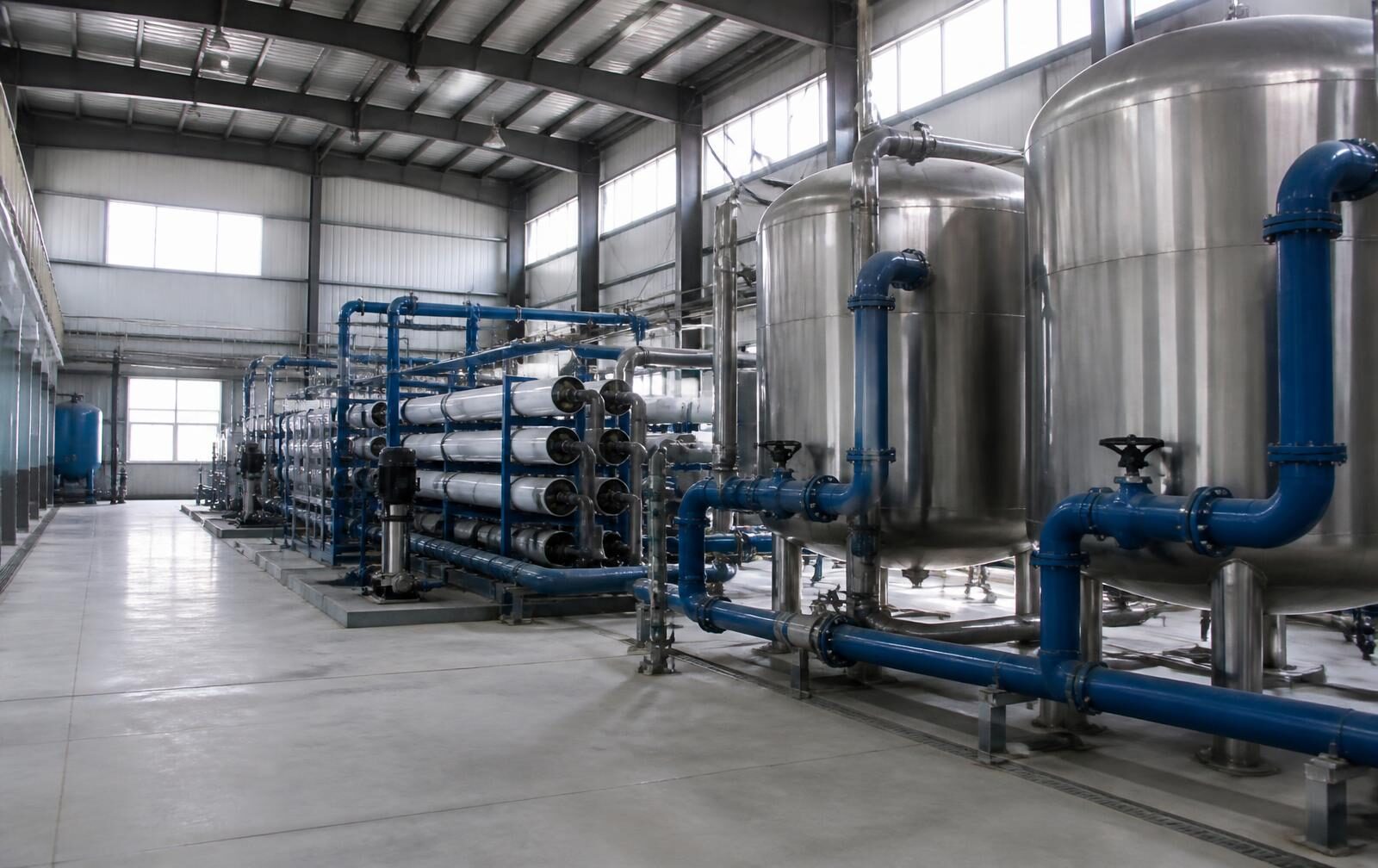 Interior of an industrial water treatment plant with stainless steel filtration vessels